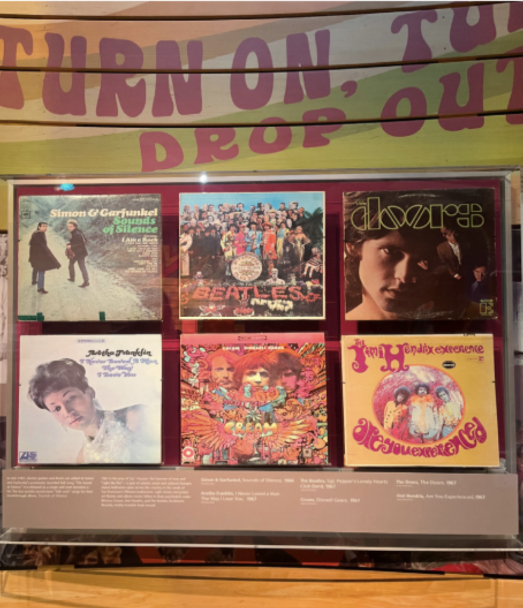 (Above) On display at Bethel Woods Center for the Arts are six albums that represent some of the music present during the rise of the hippie movement. The bright colors on the album covers highlight the psychedelic style of the hippie movement. 